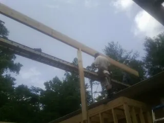 Carpenter setting a ridge beam over a new addition frame — Ice Dam Removal by Roofing Brothers in Cartwright