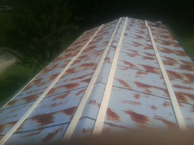 Rusted metal roof panels with new wood purlins before replacement — Storm Damage Roof Repair in Cartwright by Roofing Brothers