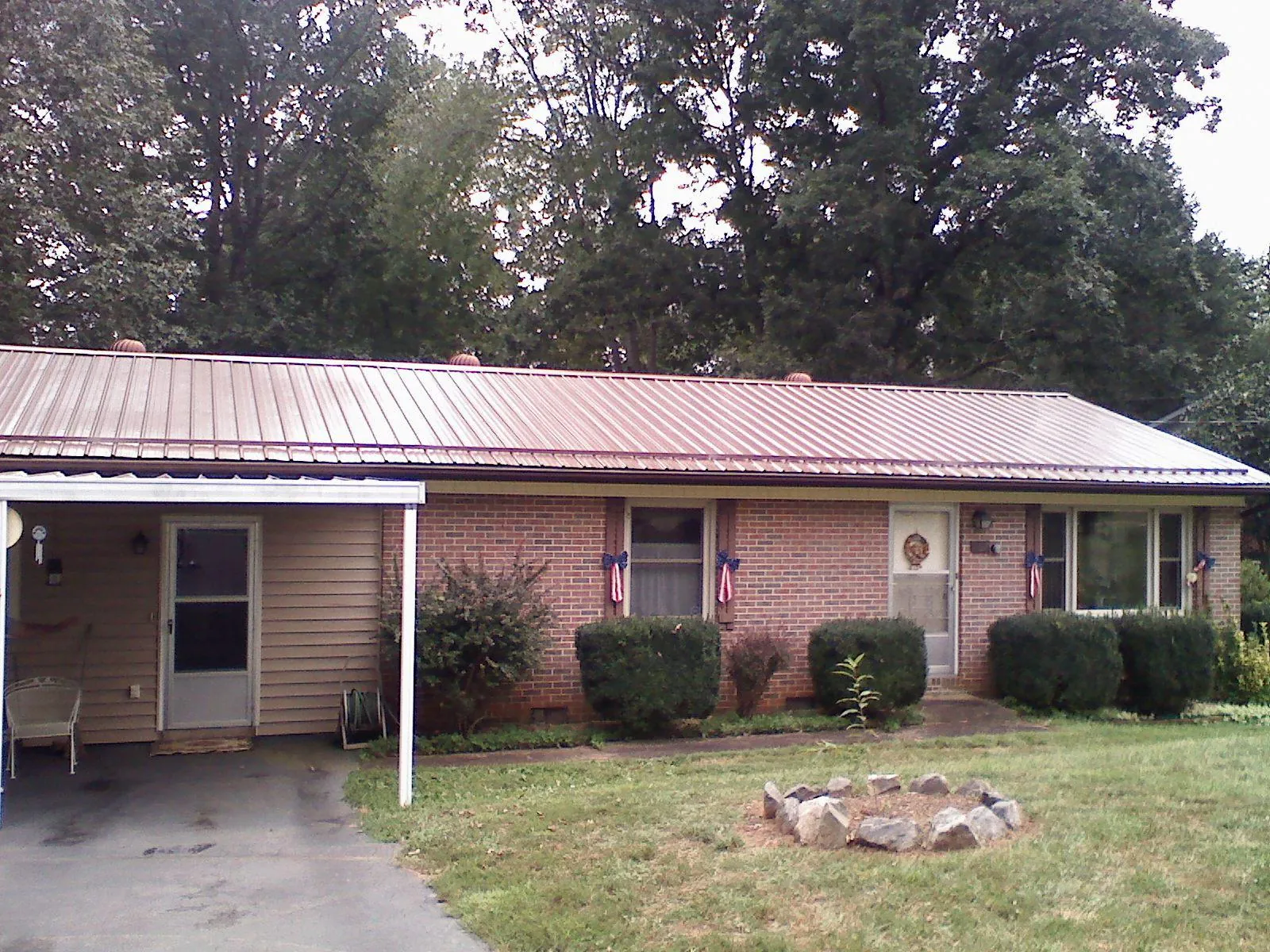 Bronze metal roof and carport on a brick ranch home — Roof Repair work by our crew in Cartwright